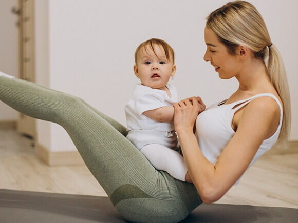 Mãe e filho em posturas de ioga em um tapete, promovendo bem-estar e conexão.
