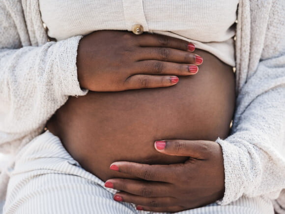 mulher grávida com as mãos envolvendo a barriga