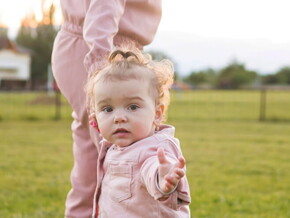 Mãe andando com sua filha pequena em uma fazenda.