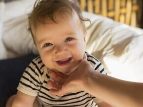Bebê sorrindo nas mãos da mãe, por Nestlé Baby & Me