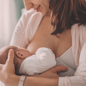 Smiling woman breastfeeding her baby