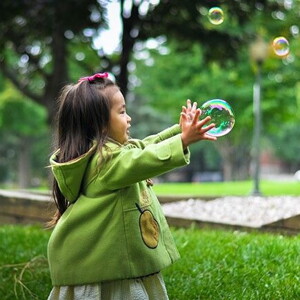 criança brincando com bola de sabão 