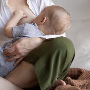 Imagem de uma mãe segurando um bebê enquanto amamenta ele