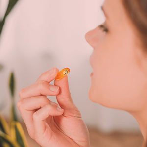 Side view of a woman taking a supplement