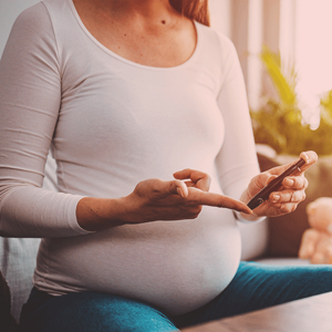 Pregnant woman doing a diabetes test with an epipen.