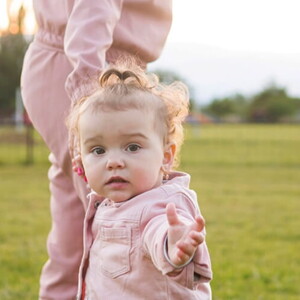 Mãe andando com sua filha pequena em uma fazenda.