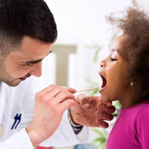 médico examinando a garganta de uma menina