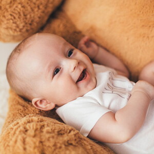 bebê sorrindo, vestindo body branco