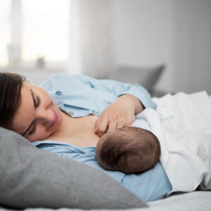 mulher amamentando um bebê enquanto está deitada