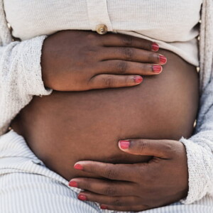 mulher grávida com as mãos envolvendo a barriga