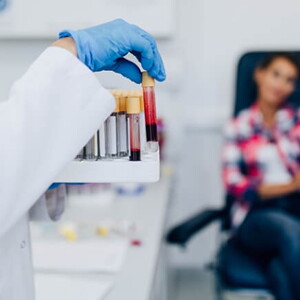 Mulher manuseando tubos de ensaio com amostras de sangue