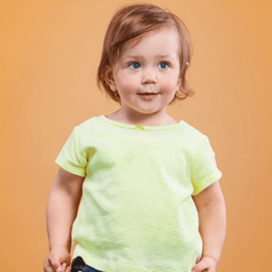 Menino loiro de olhos claros vestindo camiseta amarela e calça jeans