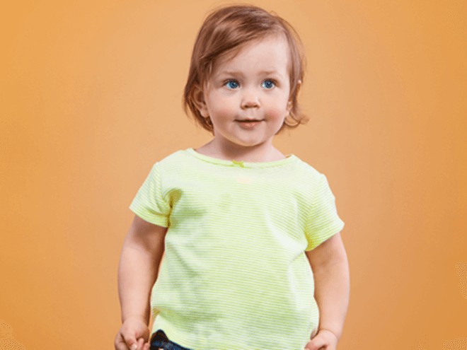 Menino loiro de olhos claros vestindo camiseta amarela e calça jeans