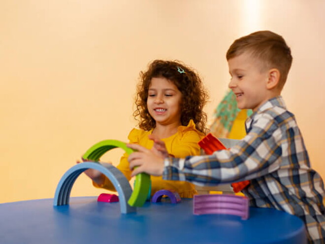 um menino e uma menina brincando com brinquedos pedagógicos