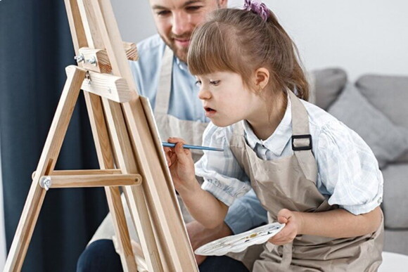 Criança com síndrome de down em uma aula de pintura