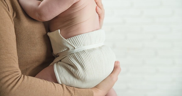 Mulher embalando delicadamente um bebê em seu colo