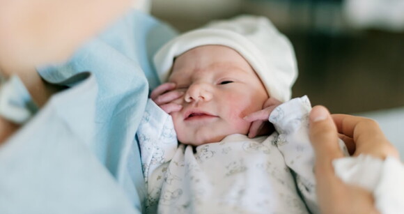 Imagem de um recém-nascido no colo de sua mãe