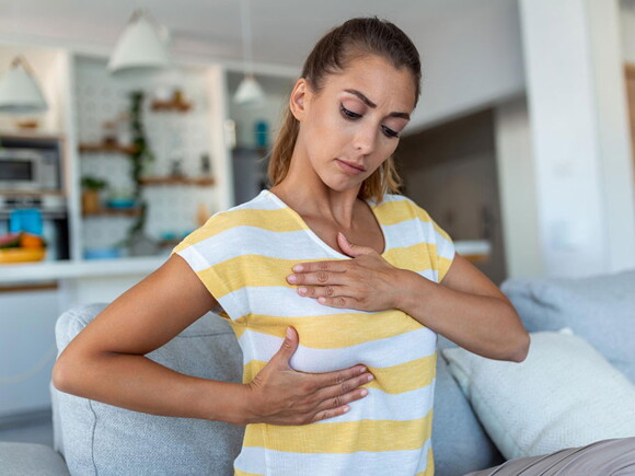 Foto de mulher examinando os próprios peitos