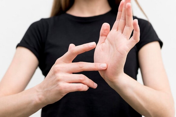 Imagem de uma mulher apalpando a palma de sua mão