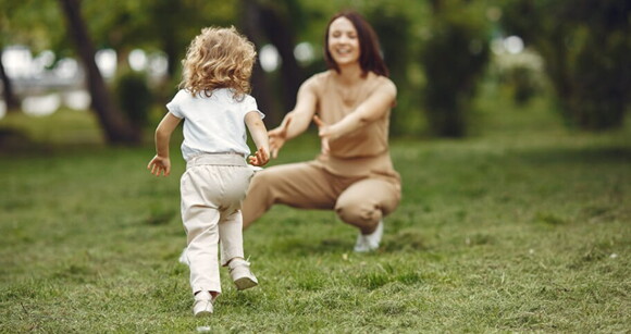 Uma mulher e uma criança brincando alegremente ao ar livre